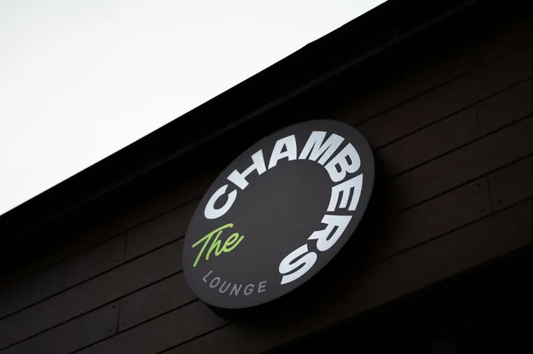 Круглая вывеска The Chambers Lounge на фасаде